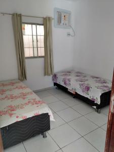 two beds in a room with a window at marés de milagres in São Miguel dos Milagres