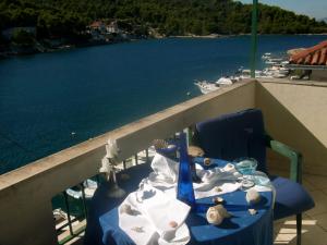 einen Tisch auf einem Balkon mit Blick auf das Wasser in der Unterkunft Apartments Kaleb - next to the seashore in Stomorska