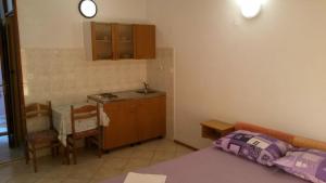 Zimmer mit einer Küche, einem Bett und einem Tisch in der Unterkunft Apartments Kaleb - next to the seashore in Stomorska