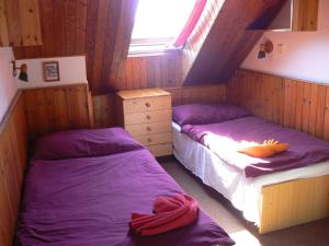 2 camas en una habitación pequeña con sábanas moradas en Penzion Kitty, en Lučany nad Nisou