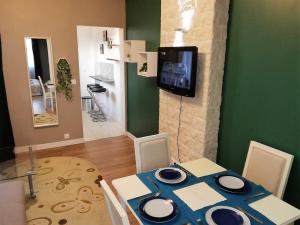 Un comedor con una mesa y un televisor en la pared. en Appartement refait par architecte. Proche de la gare et le centre de Reims, en Reims