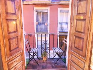 アリカンテにあるStyle City Center HappyAlicanteの椅子2脚とピンク色の建物のあるバルコニー