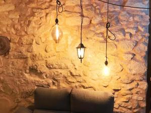 アリカンテにあるStyle City Center HappyAlicanteの3つのライトが付いた石の壁に置かれたソファ