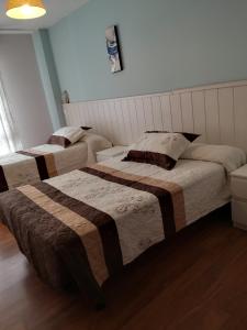 A bed or beds in a room at Hostal Campoamor