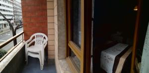 a white chair sitting on the balcony of a building at Hostal Campoamor in Gijón