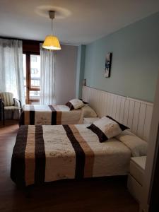 A bed or beds in a room at Hostal Campoamor