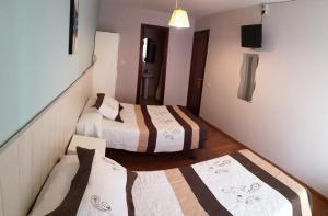 A bed or beds in a room at Hostal Campoamor