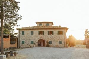 ein großes Steingebäude mit einem Turm darüber in der Unterkunft Perelli Winery in Bucine