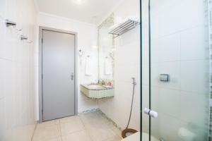 a bathroom with a glass shower and a sink at JR Hotel in Presidente Prudente