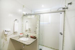 a bathroom with a sink and a shower at JR Hotel in Presidente Prudente