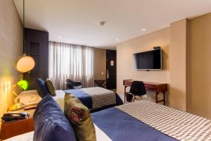 Habitación de hotel con 2 camas y TV de pantalla plana. en Hotel Regina en Bogotá