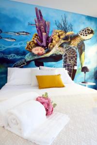 ein Schlafzimmer mit einem Bett mit einem Wandbild von Meeresschildkröten in der Unterkunft Le Jardin Secret de Faro Guesthouse in Faro