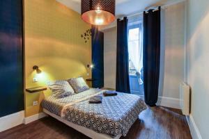 Schlafzimmer mit einem Bett und einem Fenster in der Unterkunft LE DORMEUR DU VAL - TOPDESTINATION DIJON - Centre ville - Classé 3 étoiles in Dijon