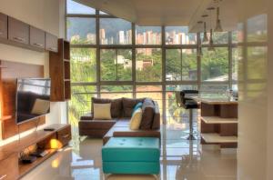 sala de estar con sofá y ventana grande en Apartamento Lleras AC Hot Tub, en Medellín