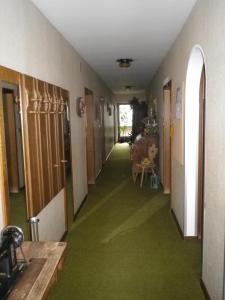 a hallway with green flooring in a house at Pension Rainhof in Santa Maddalena