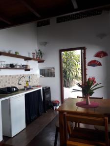 cocina con mesa y cocina con ventana en Casa Shuhari, en Morro de São Paulo