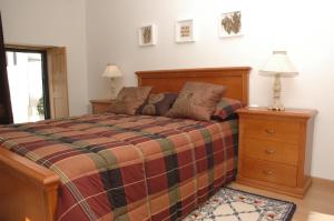 een slaapkamer met een bed en een lamp op een ladekast bij Casa Da Canada in Seia