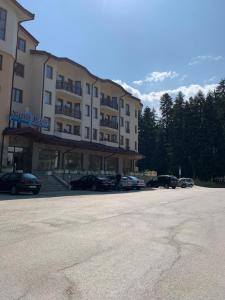 a large building with cars parked in a parking lot at Studios -Villa Park SV in Borovets
