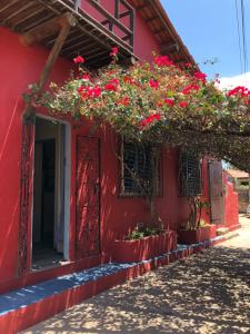 un edificio rojo con flores a un lado en IL PEVERO, en Flecheiras