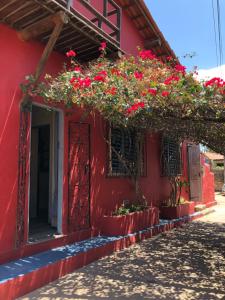 a red building with flowers on the side of it at IL PEVERO in Flecheiras