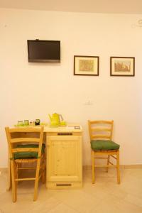 stół z 2 krzesłami i telewizor na ścianie w obiekcie La Brenta Vecchia w mieście Vigodarzere