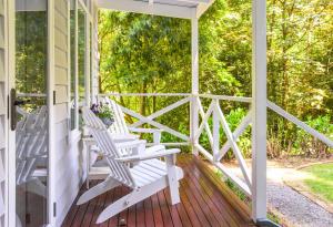 a porch with two white rocking chairs on it at Franklin - An Escape to the Country in Sassafras