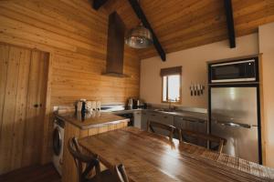 a kitchen with a dining table and a kitchen with wooden walls at Alpine Lodges in Lake Tekapo