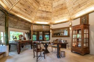 a large room with a wooden ceiling and tables and chairs at Phu Chaisai Mountain Resort Chiang Rai in Mae Salong Nai
