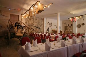 una sala de banquetes con mesas blancas y sillas rojas en Landhaus Lebert Restaurant, en Windelsbach