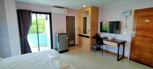 a bedroom with a bed and a desk and a television at TK Thongrak Apartment in Hat Yai +29 photos