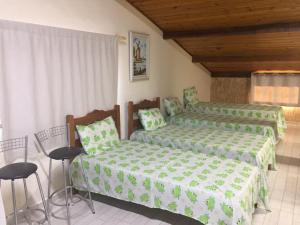 Un dormitorio con dos camas y una mesa y sillas. en Sótão Studio Relax, en Peruíbe