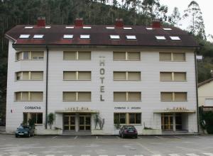 un gran edificio blanco con techo marrón en Hotel Canal, en Unquera