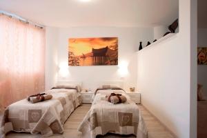 Residence Ferrucci في براتو: ثلاثة أسرة في غرفة مع لوحة على الحائط