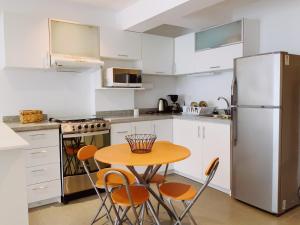 una cucina con tavolo, sedie e frigorifero di Mar , Familia & Diversion en San Bartolo a San Bartolo