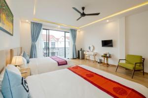 1 dormitorio con 2 camas y ventilador de techo en Q Villa Hoi An, en Hoi An