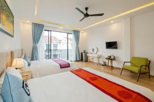 a bedroom with two beds and a ceiling fan at Q Villa Hoi An in Hoi An