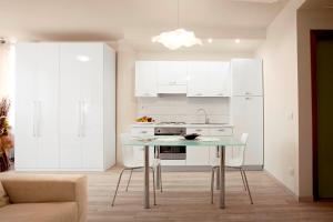 a kitchen with white cabinets and a table in a room at Residence Ferrucci in Prato