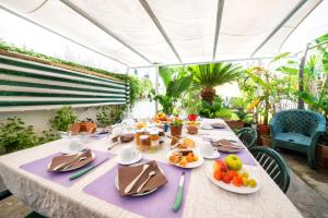 stół z talerzami owoców na fioletowej tkaninie stołowej w obiekcie A Casa di Mario w mieście Ischia
