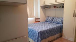 Dormitorio pequeño con cama con edredón azul en Estilo Residence I, en São Lourenço