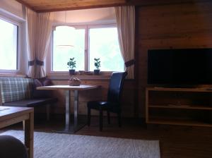 ein Wohnzimmer mit einem Tisch und einem TV in der Unterkunft Appartement Freiblick in Ramsau im Zillertal