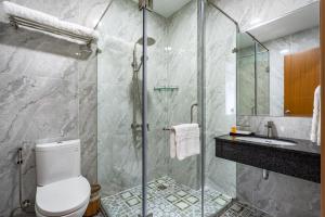 a bathroom with a shower and a toilet and a sink at Emerald Central in Ho Chi Minh City