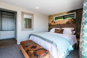 a bedroom with two beds and a window at Moana on Waikare - You've Got It Maid in Oneroa