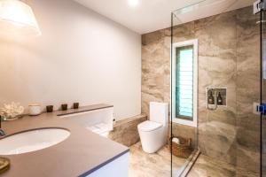 a bathroom with a toilet and a sink and a shower at Moana on Waikare - You've Got It Maid in Oneroa +8 photos