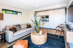 ein Wohnzimmer mit einem Sofa und einem Tisch in der Unterkunft Moana on Waikare - You've Got It Maid in Oneroa