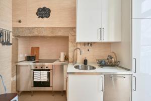 a small kitchen with white cabinets and a sink at Spacious Apartment in the Perfect Lisbon Location, By TimeCooler in Lisbon