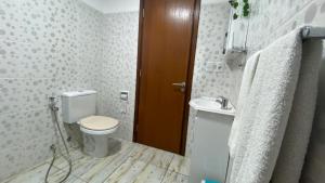 a bathroom with a toilet and a sink at Hotel Imperial in Melo +9 photos