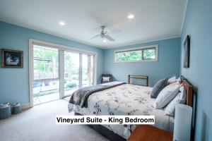 Dormitorio azul con cama y ventana en Grey Ridge Vineyard Experience, en Alexandra