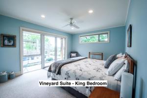 a blue bedroom with a bed and a window at Grey Ridge Vineyard Experience in Alexandra