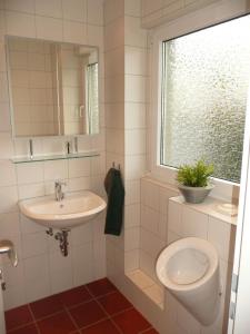 a bathroom with a sink and a toilet and a window at Quartier Ostheim in Cologne