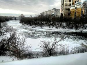 a river in a city with snow and buildings at Отель-хостел ПушкинЪ in Omsk
